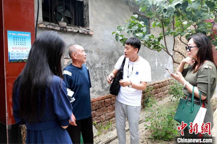 村民介绍使用污水处理设备后农户的生活习惯和环境变化。　刘光花 摄