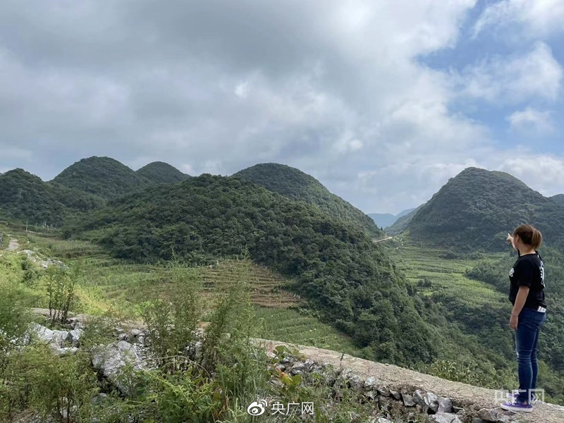 马艺珈伊指向远处山丘，自行车赛道还要再拐几个弯